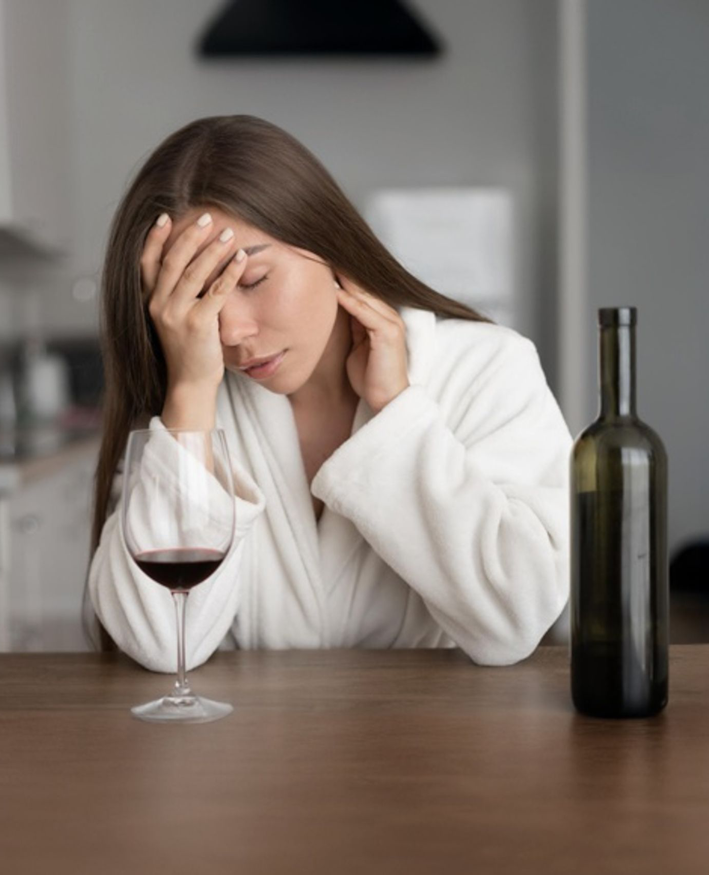 donna con mal di testa dopo aver bevuto vino rosso
