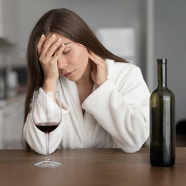 donna con mal di testa dopo aver bevuto vino rosso